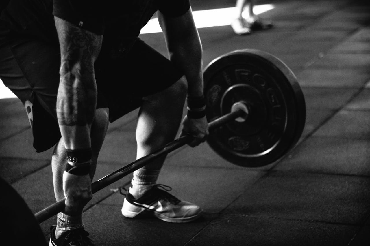 hero-img A powerful black and white image of a man deadlifting in a gym, showcasing strength and fitness.
